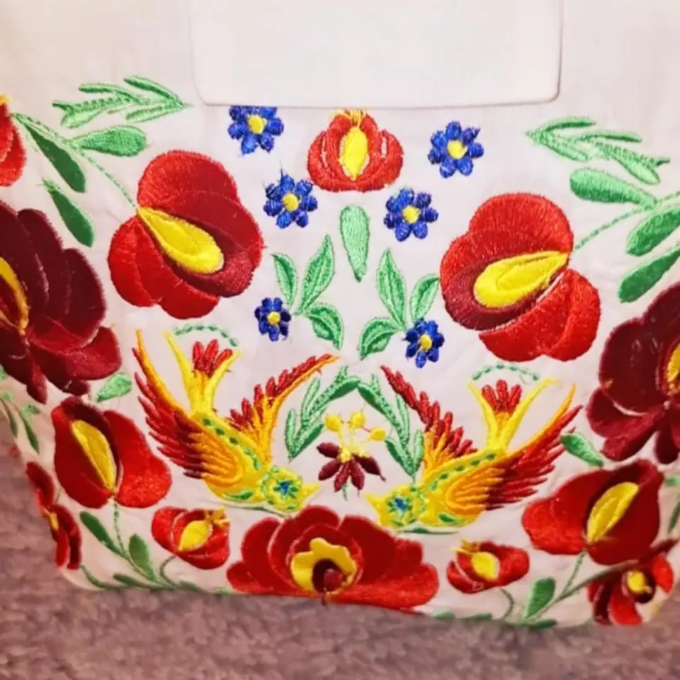 Színes kalocsai virágminta hímzése fehér textilen
